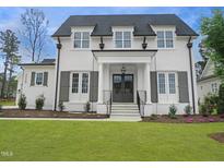 Beautiful two-story house featuring a white brick exterior, black shutters, and a well-manicured lawn at 7723 Roberts Rd, Apex, NC 27523