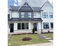Charming new construction townhome featuring a modern white facade and manicured lawn at 913 Myers Point Dr, Morrisville, NC 27560