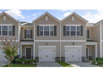 Inviting tan two-story townhome with a single-car garage and attractive landscaping at 216 Starlight St, Sanford, NC 27330