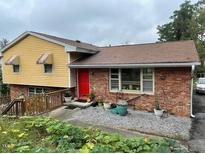 Charming two-story home with brick and yellow siding, complemented by a lush front yard at 2201 Valiant St, Raleigh, NC 27610
