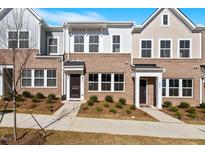 Charming brick townhome exterior with manicured landscaping and inviting entryway at 260 Chesapeake Commons St # 156, Garner, NC 27529