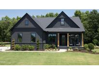 Charming home featuring a dark exterior, well-manicured lawn, and a welcoming front porch with wooden pillars at 306 Golden Leaf Farms Rd, Angier, NC 27501