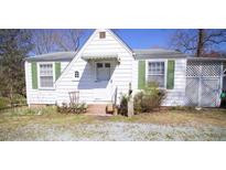 Charming bungalow with a white exterior, green trim, and well-maintained front yard at 3117 Cheek Rd, Durham, NC 27704