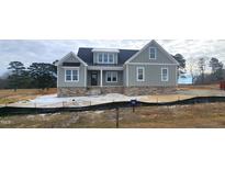 Inviting two-story home with gray siding, stone accents, and a welcoming front porch at 35 Wheatfield Ln, Youngsville, NC 27596