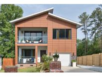 Stunning two-story modern home featuring dual balconies, warm wood accents, and an attached garage at 1012 Cook Rd, Durham, NC 27713