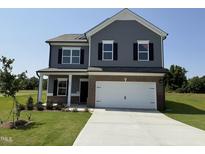 Charming two-story home boasts gray siding, black shutters, and a spacious two-car garage at 106 E Victory View. Ter, Smithfield, NC 27577