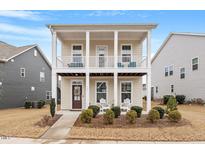 Charming two-story home boasts a covered front porch and second story balcony at 109 Beldenshire Way, Holly Springs, NC 27540
