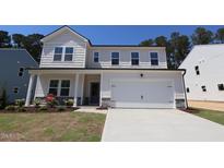 Charming two-story home featuring a covered porch and a two-car garage, landscaped yard and a bright exterior at 1229 Dimaggio Dr # 8, Raleigh, NC 27616
