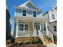 Charming two-story home featuring a welcoming front porch with white railings and a light blue exterior at 1250 Barreto Dr, Wendell, NC 27591