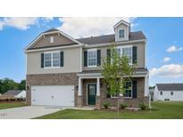 Two-story home with a mix of brick and siding, a two-car garage, and a covered front porch at 168 Paper Birch Way, Fuquay Varina, NC 27526