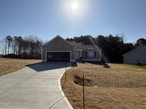 Charming one-story home with an open garage, concrete driveway, and a well-maintained lawn on a sunny day at 175 Magnolia Run Way, Benson, NC 27504
