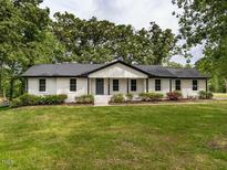 Charming one-story home with white brick, black trim, and a well-manicured lawn at 206 Ellington Rd, Graham, NC 27253
