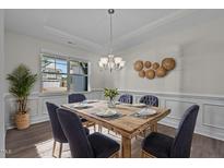 Elegant dining room with a rustic wooden table, stylish blue chairs, and decorative wall accents at 25 Bourne Dr, Franklinton, NC 27525