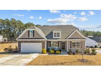 Charming home featuring stone accents, attached two-car garage, and covered front porch with inviting bench seating at 25 Bourne Dr, Franklinton, NC 27525
