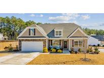 Charming home featuring a stone-accented facade, manicured lawn, and welcoming front porch at 25 Bourne Dr, Franklinton, NC 27525