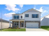 Charming two-story home featuring a brick and vinyl exterior, well-manicured lawn, and two car garage at 276 Hanging Elm Ln, Fuquay Varina, NC 27526
