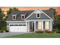 Charming two-story home with blue siding, white trim, dormer windows and an attached two-car garage at 294 Arcadius Dr, Clayton, NC 27520