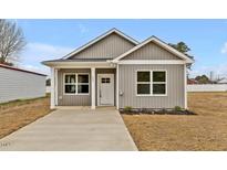 Charming single-story home showcasing a gray exterior, covered front porch, and pristine landscaping at 307 Wondertown Dr, Erwin, NC 28339