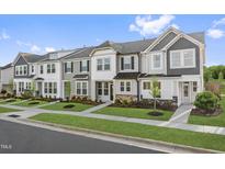 Charming townhomes with gray and white exteriors, manicured lawns, and well-maintained sidewalks, create inviting street appeal at 312 Church St # 36, Wendell, NC 27591
