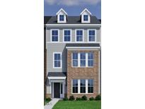 Modern townhome with a brick and gray facade, complemented by well-manicured landscaping at 315 Chesapeake Commons St # 102, Garner, NC 27529