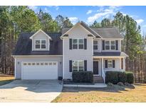 Two-story home with gray siding, black shutters, and a two-car garage at 329 Silver Creek Dr, Clayton, NC 27520