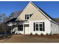 Charming white exterior elevation with black shutters and a covered side porch at 333 S Main St, Four Oaks, NC 27524
