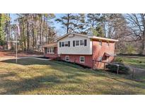 Charming two-story home with a mix of brick and light siding nestled among mature trees at 3416 Oates Dr, Raleigh, NC 27604