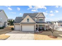 Charming two-story home boasts a two-car garage and beautifully landscaped front yard at 372 Lynshire Ave, Clayton, NC 27527
