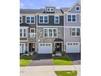Charming townhome exterior features stone accents, a one-car garage, and well-maintained landscaping at 509 Sherron Rd # 25, Durham, NC 27703