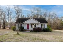 Charming one-story home featuring a red front door and established landscaping at 113 Belgium Pl, Zebulon, NC 27597