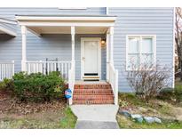 Charming home featuring a cozy front porch with brick steps and manicured landscaping at 1620 Oakland Hills Way, Raleigh, NC 27604