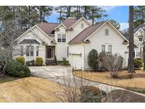 Charming two-story traditional style home with a manicured lawn and driveway leading to a garage at 217 Old Pros Way, Cary, NC 27513