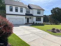 Charming two-story home featuring a pristine lawn, concrete driveway, and classic black and white color scheme at 3204 Overlook Ct, Burlington, NC 27215
