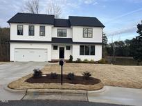 Beautiful two-story home boasts a modern white exterior, black accents, and an attached two-car garage at 3204 Overlook Ct, Burlington, NC 27215
