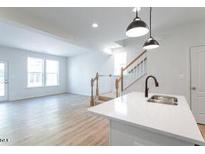 Bright kitchen featuring stainless steel appliances, white cabinets, and an island with pendant lighting at 343 Church St # 66, Wendell, NC 27591