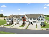 New townhomes featuring modern architecture, attached garages, and lush landscaping at 345 Church St # 65, Wendell, NC 27591