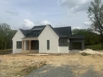 New home showing white brick, dark gray siding, black roof and wood porch posts at 395 Meadow Walk Dr, Fuquay Varina, NC 27526