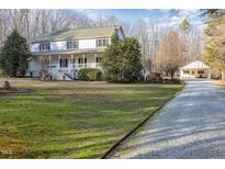 Charming two-story home with a welcoming front porch and a long driveway leading to a detached garage at 69 Holly Tree Dr, Timberlake, NC 27583