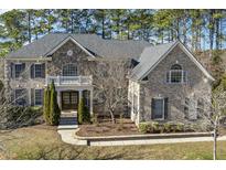 A beautiful exterior elevation view of a brick and stone home with a well-manicured lawn and mature trees at 1013 Timber Mist Ct, Cary, NC 27519