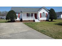 Charming home featuring a well-manicured lawn and front porch, perfect for relaxing outdoors at 104 Eddy Ct, Benson, NC 27504