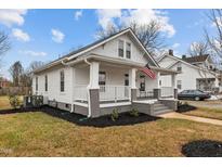 Charming white home with a inviting front porch and an American flag at 111 N Marshall St, Graham, NC 27253