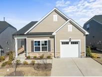 Charming single Gathering home boasting stone accents, a single car garage, and manicured landscaping at 1255 White Flint Cir, Durham, NC 27703