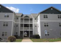 Attractive multi-story building exterior featuring reserved parking signage and multiple balconies at 2000 University Woods Rd # 201, Raleigh, NC 27603