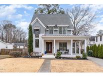 Charming two-story home featuring a covered front porch and professionally landscaped front yard at 2005 Bernard St, Raleigh, NC 27608