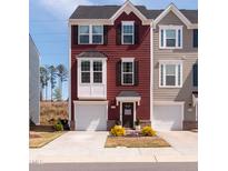 Charming three-story townhouse showcasing beautiful curb appeal and attached one-car garage at 306 Brier Summit Pl, Durham, NC 27703
