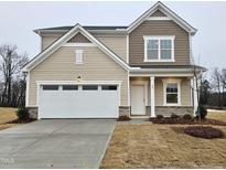 Charming two-story home featuring a two-car garage, landscaped yard, and traditional design elements at 40 Rolling Banks Dr, Louisburg, NC 27549