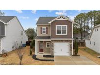 Charming two-story home with a stone-accented garage, red front door and manicured landscaping at 532 Smithridge Way, Fuquay Varina, NC 27526