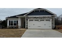 Charming single-story home showcasing a stone facade, and a two-car garage at 56 Cooper Branch Ct, Fuquay Varina, NC 27526