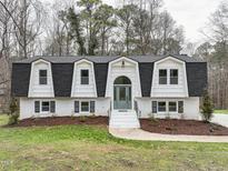 Charming two-story home featuring a symmetrical facade, black roof, and white brick exterior at 109 Chatterson Dr, Raleigh, NC 27615