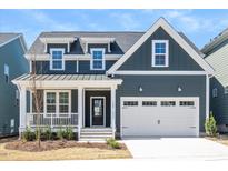 Charming home with a covered porch, two-car garage, and a well-manicured lawn at 1205 Porters Call Dr, Wendell, NC 27591